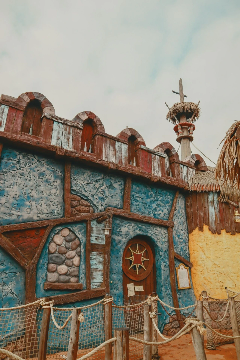 a blue and yellow building with a cross on top of it